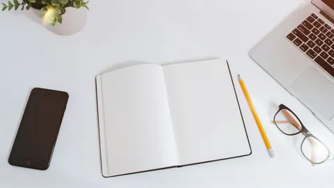 Open notebook, pencil and laptop arranged for preparing a job application